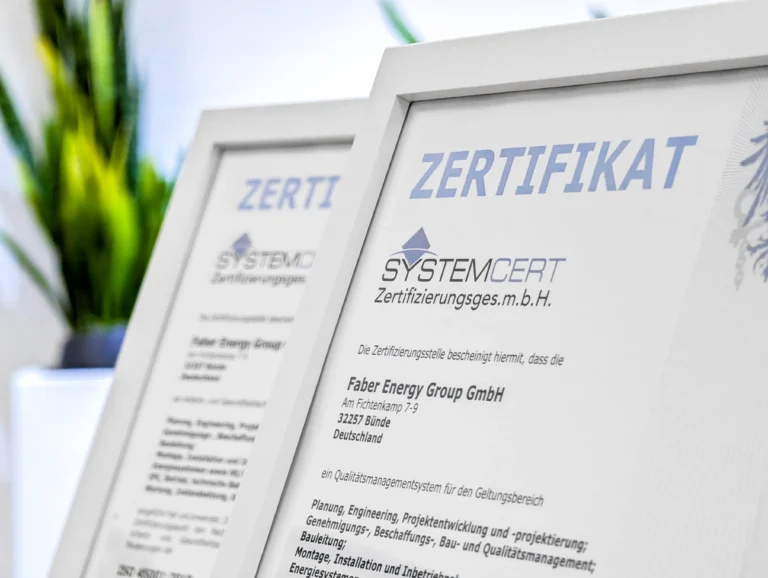 ISO-Zertifikate für Qualitätsmanagement und Arbeitsschutz – Faber Energy Group Zwei gerahmte Zertifikate der SystemCERT Zertifizierungsges.m.b.H. für die Faber Energy Group GmbH in Bünde, im Vordergrund gut sichtbar das Zertifikat für das Qualitätsmanagementsystem